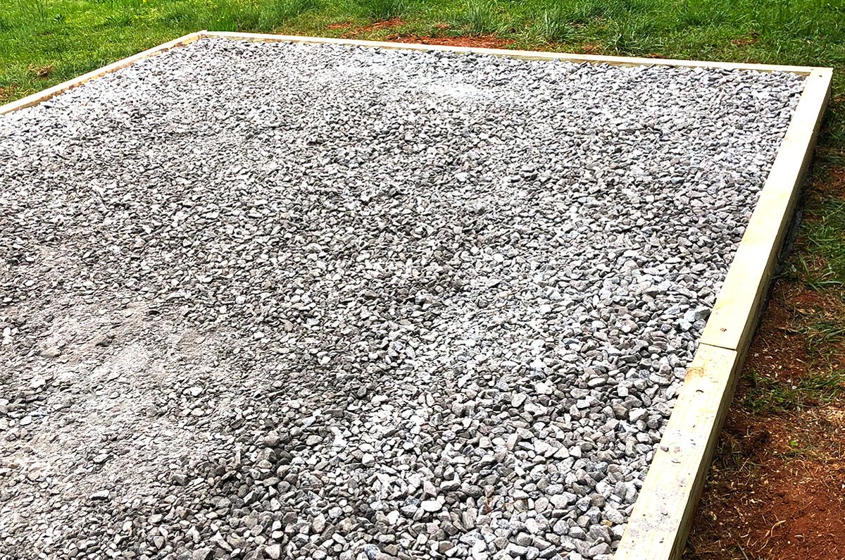Leveled gravel shed foundation pad with timber border for drainage in Greenville SC