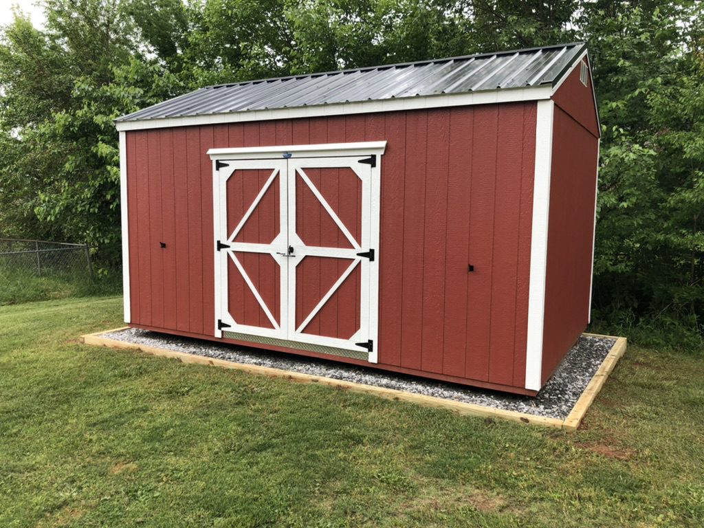 Red custom storage shed with white trim on a professional gravel foundation